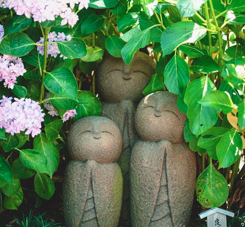 small stone statues in an asian inspired garden